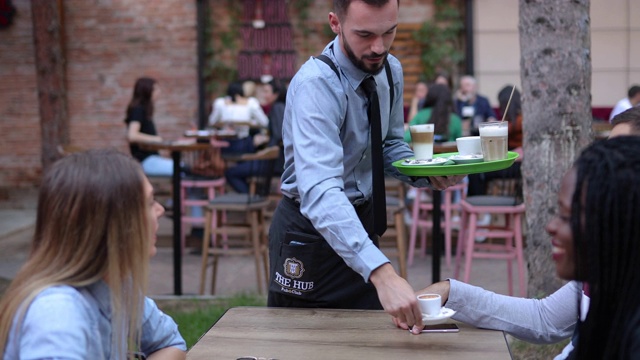 男侍者在咖啡馆的户外服务饮料视频下载