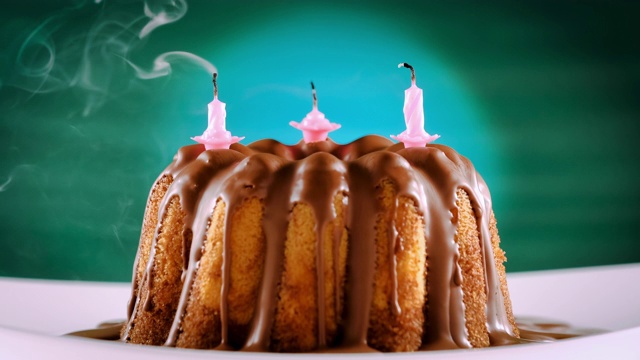 吹灭在大理石蛋糕和巧克力牛轧糖糖衣上的生日蜡烛视频下载