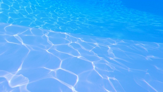 碧波荡漾在蓝色的游泳池里。抽象的背景。视频素材