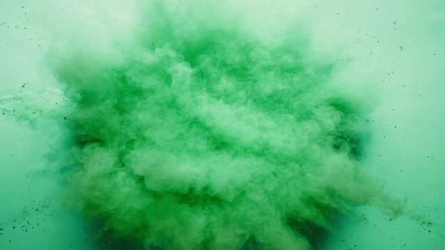 粉末状的绿色粉末在特写镜头中向镜头爆炸，超级慢镜头，淡绿色背景视频素材