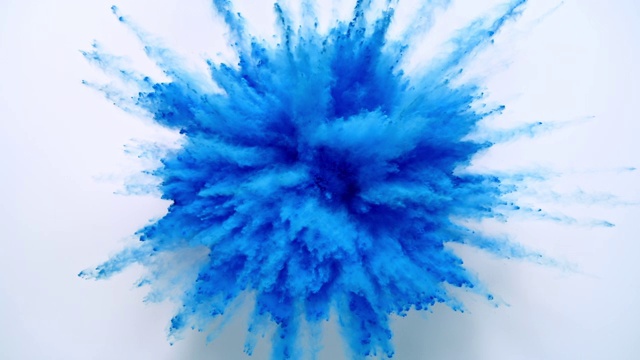 蓝色的粉末在近距离和超级慢镜头中向相机爆炸，白色的背景视频素材