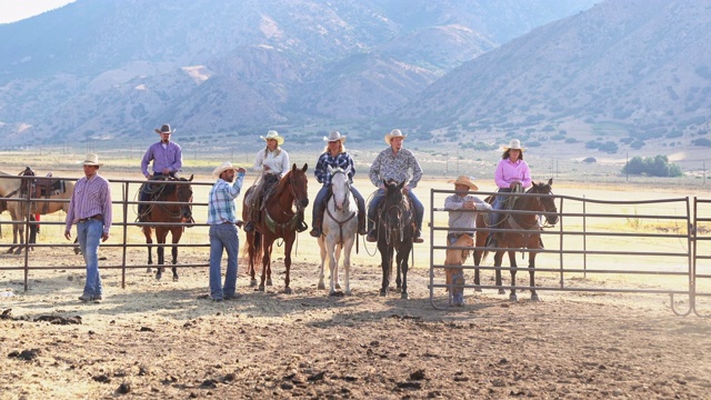 牛仔和女牛仔组一起坐在马在农场牛门4K视频视频下载