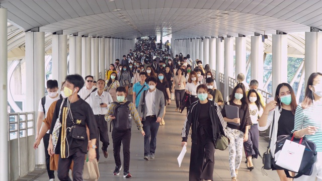 4K分辨率慢镜头拍摄亚洲人在早高峰时间在曼谷上班时戴着预防冠状病毒或新冠病毒的面罩和空气中的微尘pm 2.5视频下载
