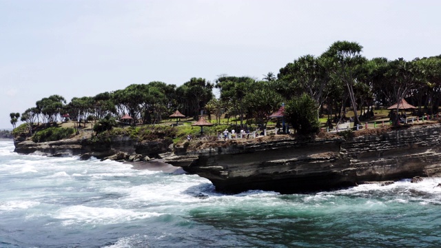 航拍的海岸线，悬崖和海浪撞向他们，爪哇印度尼西亚视频下载