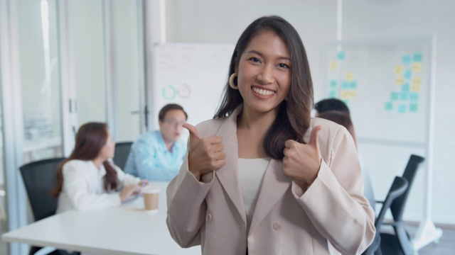 自信的亚洲女商人在同事面前竖起大拇指视频素材