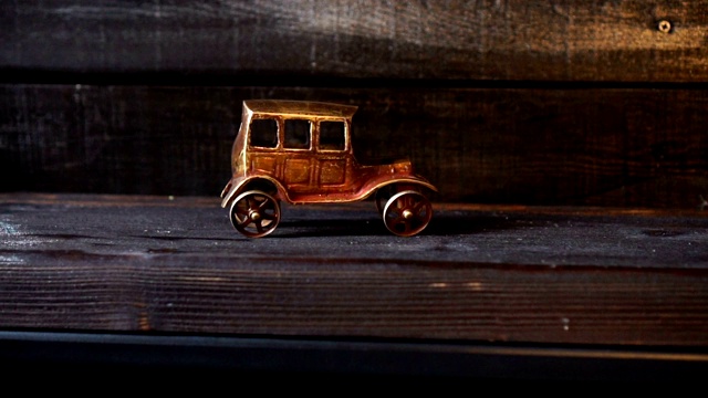 木制背景上的复古汽车的古老雕像。视频下载