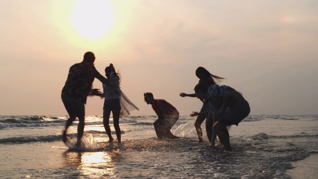 团体亚洲朋友周年旅游海滩热带。旅行者年轻的乐趣和享受溅水一起。夏天，一群朋友在海边玩水玩海。4K超高清慢动作。视频购买