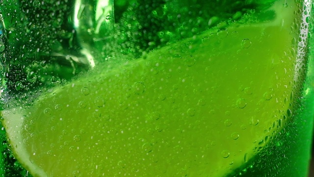 一杯苏打水下面放着一片鲜嫩多汁的青柠。视频下载