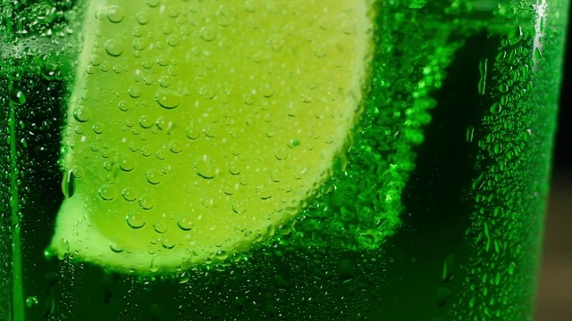 杯底新鲜多汁的青柠片，配上绿色鸡尾酒视频下载
