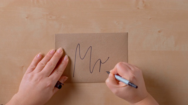 女性的手在棕色信封的背面写着“先生”视频素材
