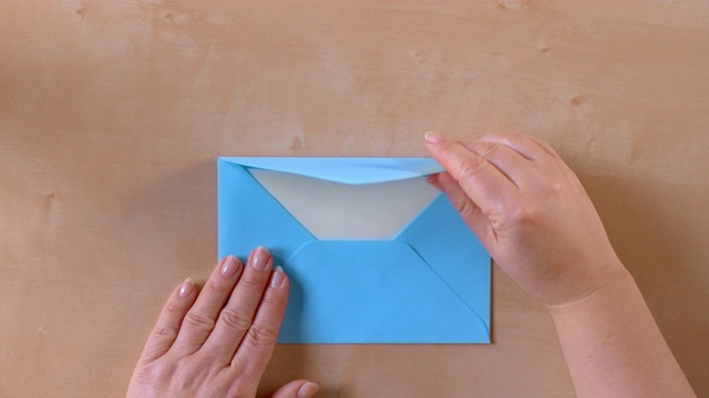 SLO MO LD手打开一个蓝色的信封，拿出一封信视频素材