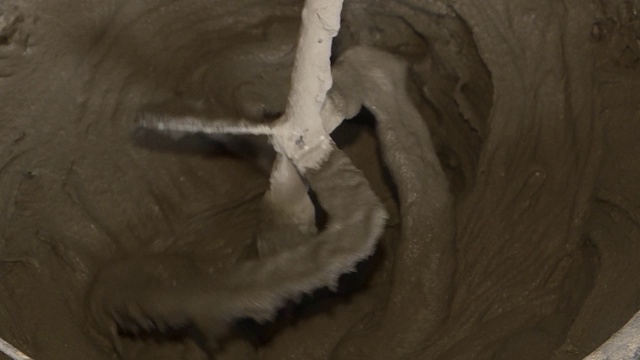 一台长搅拌机将水泥、沙子和水混合在一起。视频素材