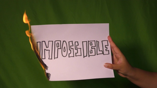 一只手握着燃烧着的纸，上面写着不可能的文字。视频下载