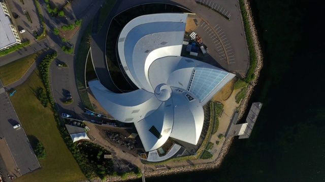 在阳光明媚的日子里，无人机在现代建筑上空盘旋，俯瞰这座城市著名的水族馆——丹麦哥本哈根视频下载
