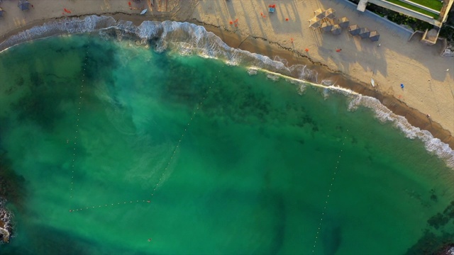 鸟瞰海浪溅在绿松石海，无人机下降在日落海滩上-雅法，以色列视频下载
