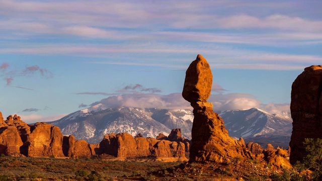 犹他州拱门国家公园，在沙漠中平衡岩石的剪影，山峰映衬着天空视频素材
