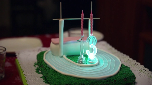 13岁生日蛋糕，上面装饰着绿色的糖果片和翻糖，模拟运动场和跳高或撑杆跳高垫视频下载