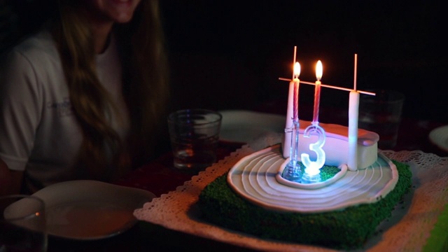 快乐的小女孩在家吹灭生日蛋糕上的蜡烛视频下载