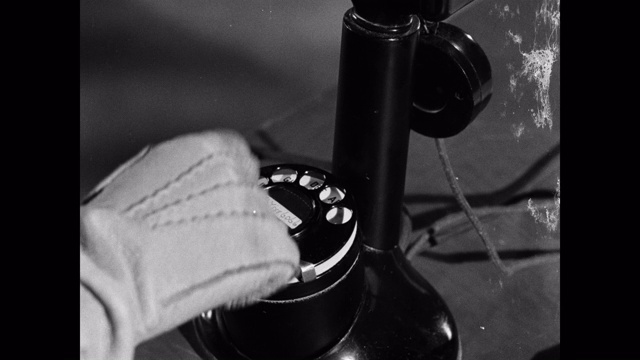 1952年，戴着手套的手在电话上拨打号码视频素材