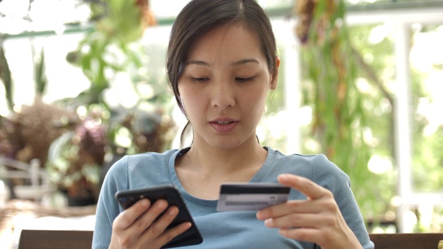 用信用卡在网上购物的亚洲女人视频素材