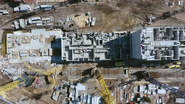 建筑工人们在建筑工地上工作的高空视频下载