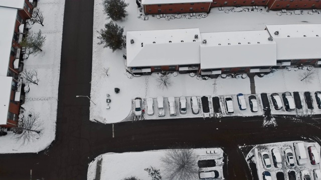 鸟瞰被雪覆盖的城市街道和房屋在雪冬天的道路覆盖视频下载