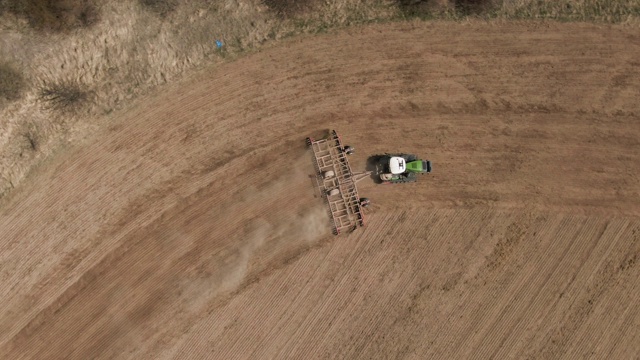 拖拉机在农地中割沟播种的俯视图视频下载
