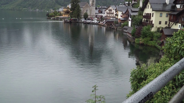 著名的哈尔斯塔特村的倾斜景观由港口、教堂、湖上的倒影和在夏天雨天覆盖云雾的山组成。位置:哈尔斯塔特度假村，萨尔兹卡默古特地区，奥地利。视频素材