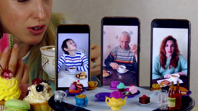 一家人在娃娃桌边用智能手机视频通话喝茶视频下载