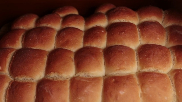 男人的双手分享刚烤好的小面包。视频下载