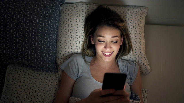 快乐的年轻恋爱女性晚上在社交媒体上发短信视频下载