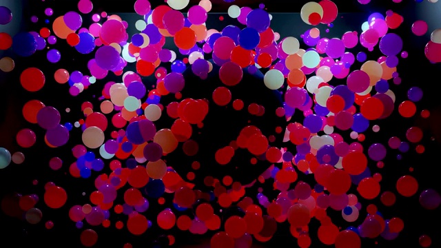 空气中彩色球的抽象组成，它们随机地发光并相互反射。多色球体在空气中作为简单的几何深色背景与灯光效果在黑暗的房间。视频下载