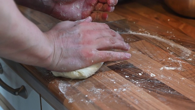手是用来形成和揉面团在厨房架子上的慢动作视频素材