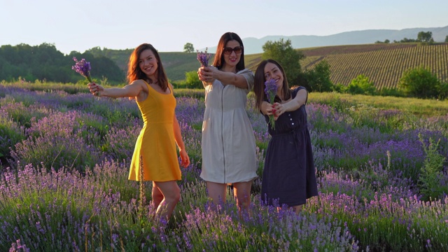 三个女人做鬼脸和摆姿势在薰衣草田视频下载