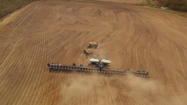 用无人机射击。一台拖拉机正在耕地。准备播种。近距离射击。4 k视频素材