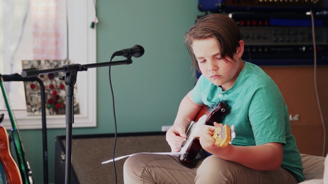 一个男孩在家里学弹吉他视频下载