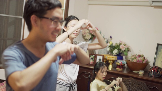 4K CU亚洲人戴眼镜跳舞练习在家里与他的家人视频素材