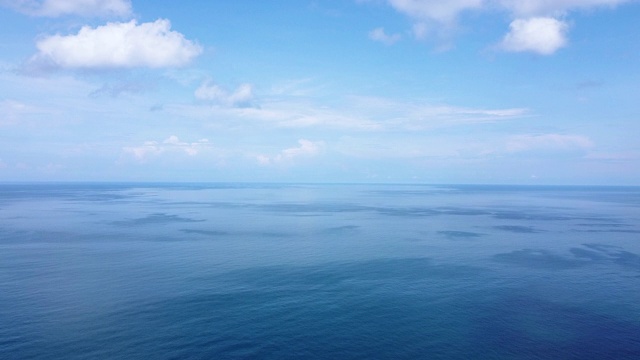 无人机飞行在平静和宁静的蓝绿色海水上方的鸟瞰图，平滑的波光粼粼的泰国普吉岛表面。视频下载