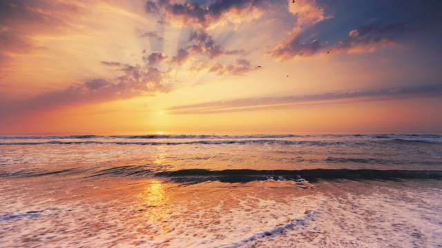 热带海滩的日出。海浪拍打着沙滩视频素材