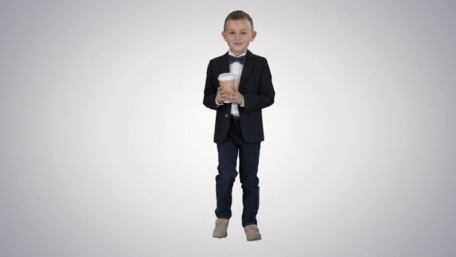 男孩走在一个带走咖啡在正式的衣服在梯度背景视频素材