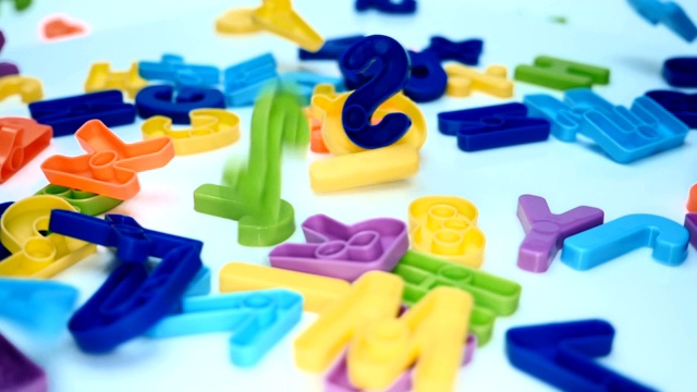 明亮的多色字母和数字从一个孩子的游戏掉下来视频素材