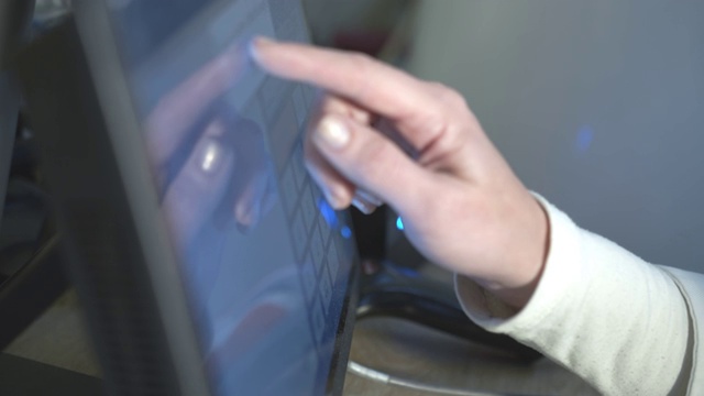 超市工作人员戴着防护手套按手指在电脑屏幕上。超市采购成本的计算视频素材