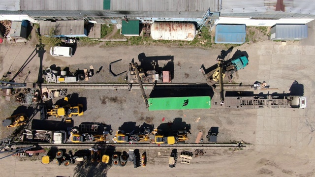 起重机在工业现场移动集装箱的俯视图。第三世界国家工厂装卸货物鸟瞰图。工业、商业、货物。视频下载