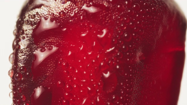 鲜红的石榴籽在白色背景和水雾中移动的超级近距离镜头。健康，充满活力的红色和抗氧化水果概念。视频下载