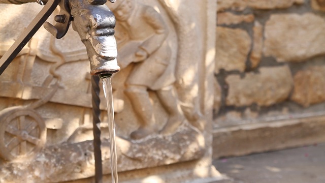 流动的饮用水的一个古老的喷泉雕塑-集中在水视频素材