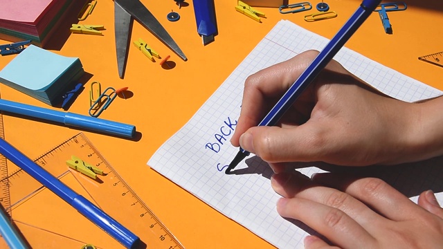 学生手画回学校的课文在纸记事本上，回到学校，学习用品视频素材