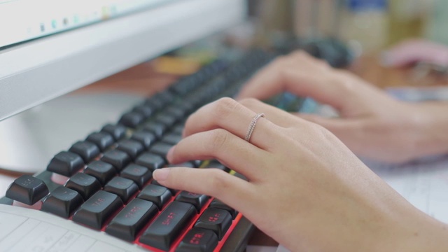 慢动作的特写，一个女人的手在一个笔记本电脑键盘上打字在木头桌子上忙着工作视频素材