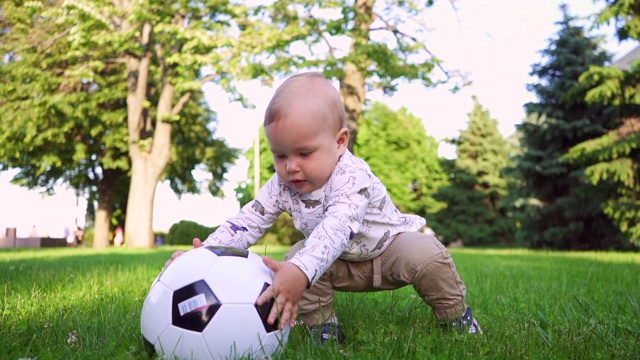 可爱的小孩在公园里玩足球。慢动作视频下载
