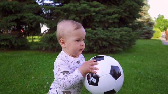 兴高采烈的孩子手里拿着球在公园里散步。慢动作视频下载