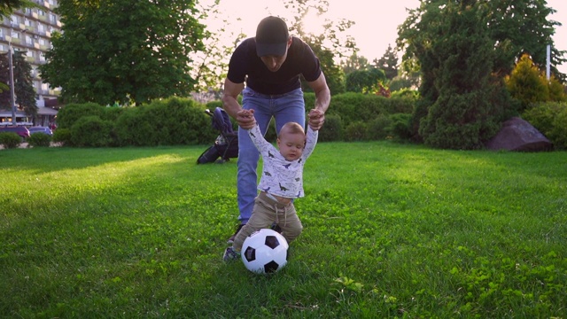 爸爸和宝宝在公园里踢足球视频下载